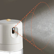 Close-up of the oil sprayer releasing a fine mist, demonstrating its automatic spraying feature.