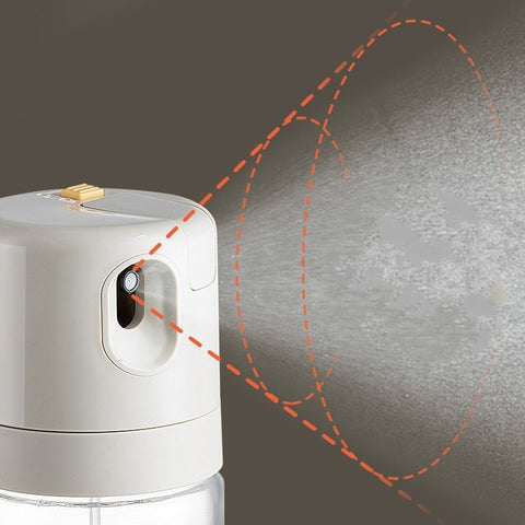 Close-up of the oil sprayer releasing a fine mist, demonstrating its automatic spraying feature.