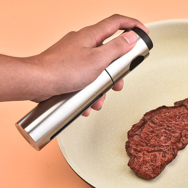 Stainless Steel Oil Sprayer Bottle used for precise oil control while cooking steak in a frying pan.