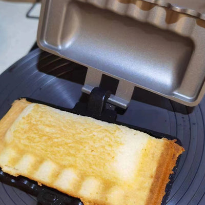 Freshly baked sandwich using the sandwich baking tray for gas induction cooker on a cooking surface.