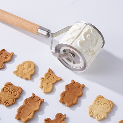 Cartoon animal biscuit mold featuring a rolling pin and assorted animal-shaped biscuits on a white background.